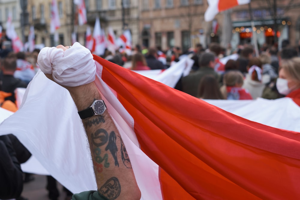a man holding a red and white flag