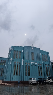a large blue building with cars parked in front of it