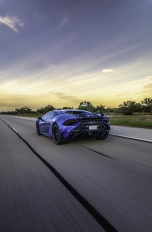 A dynamic shot of a sporty hatchback on an open road under a clear blue sky.