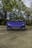 A luxurious sports car parked on a scenic road with a clear blue sky.