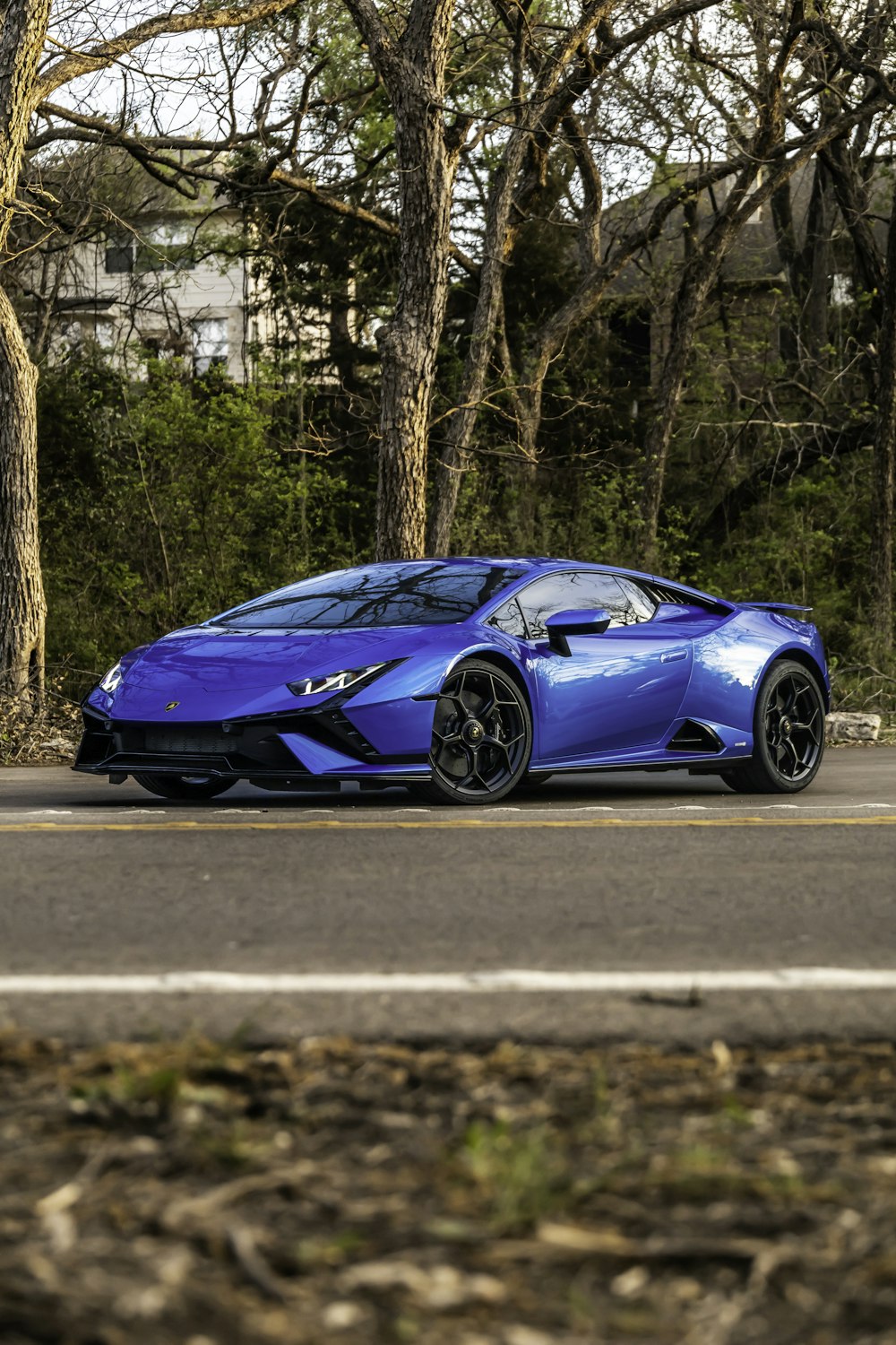 a blue sports car parked on the side of the road