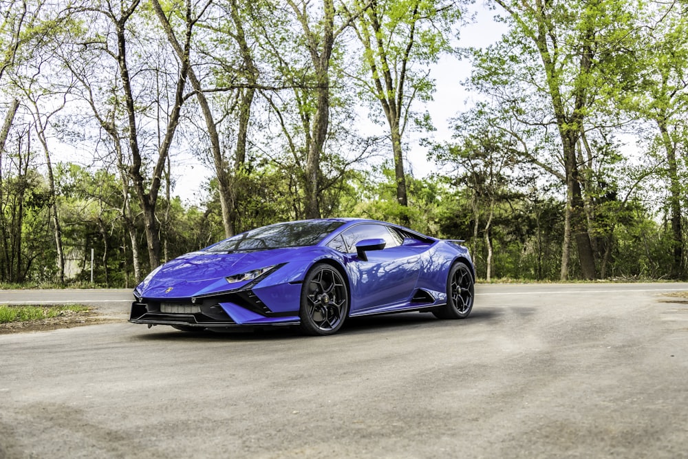 a blue sports car parked on the side of a road