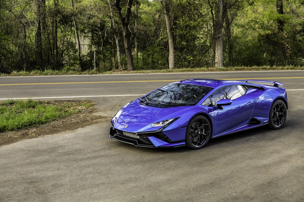 a blue sports car driving down a road