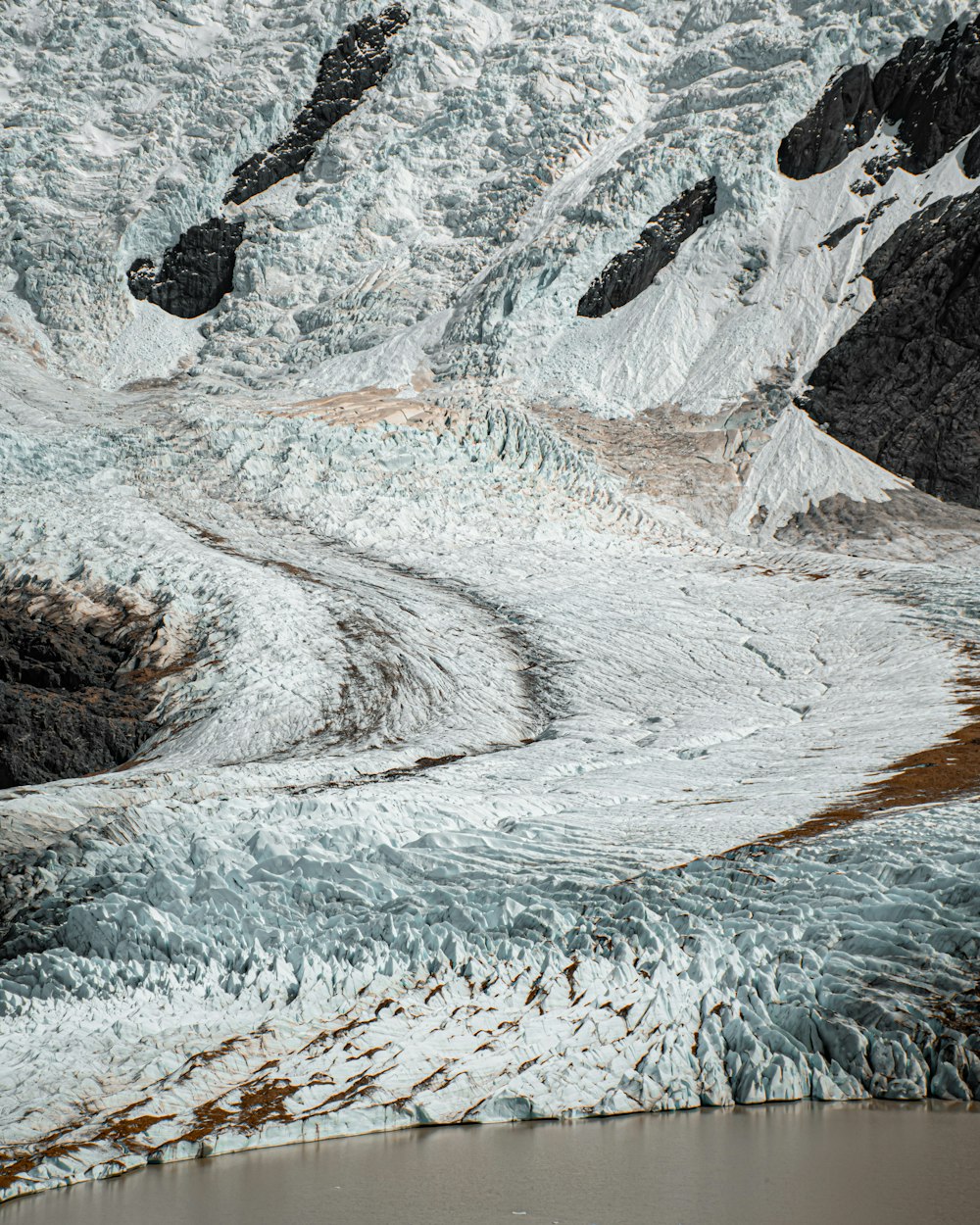 a snow covered mountain with a river running through it