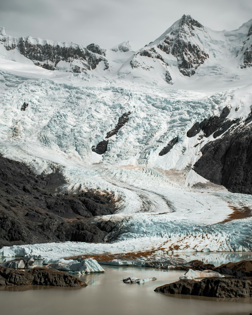 a large glacier with a mountain in the background