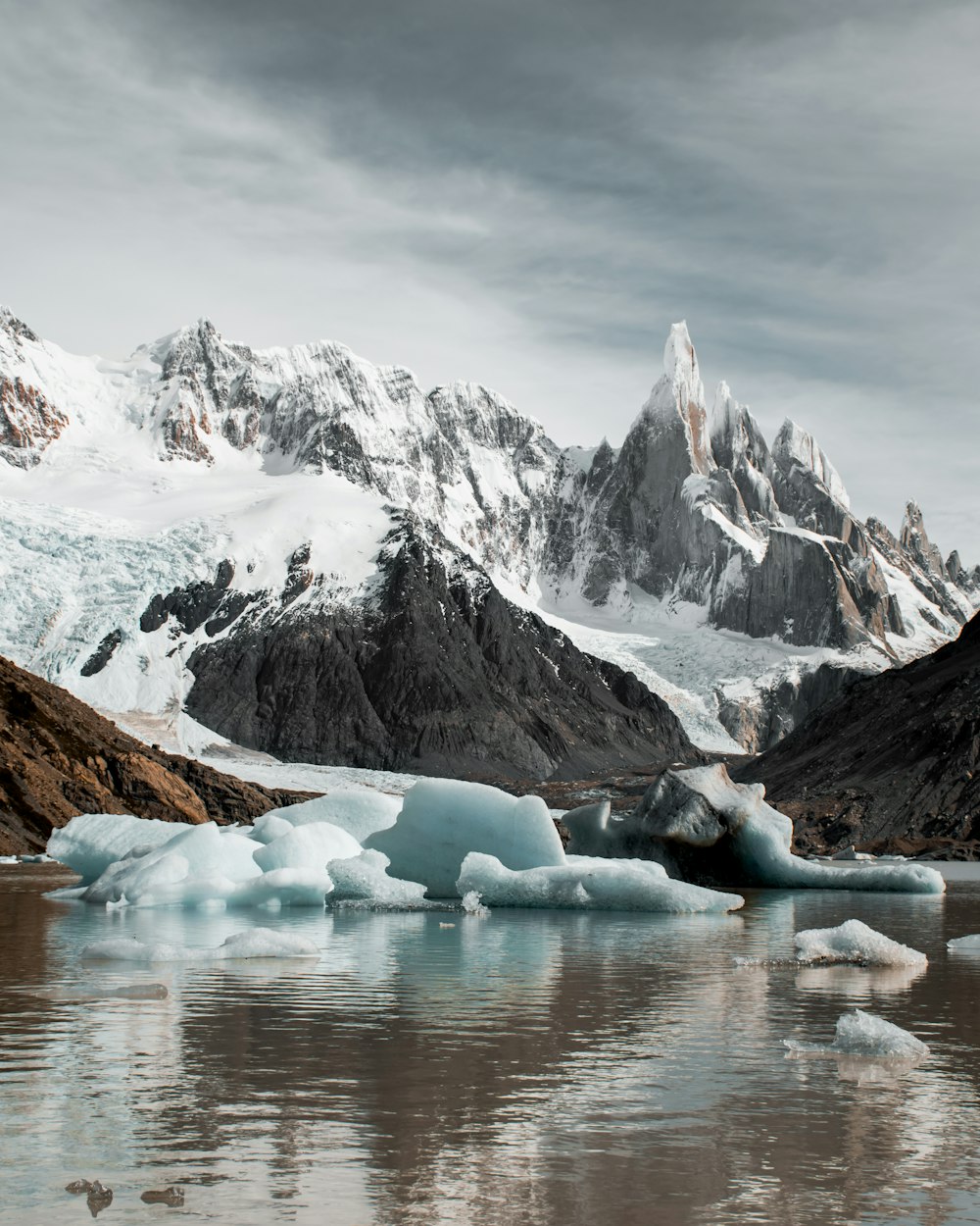 a group of icebergs floating on top of a lake