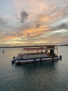 Tourists enjoying a boat ride during sunset with vibrant colors in the sky.