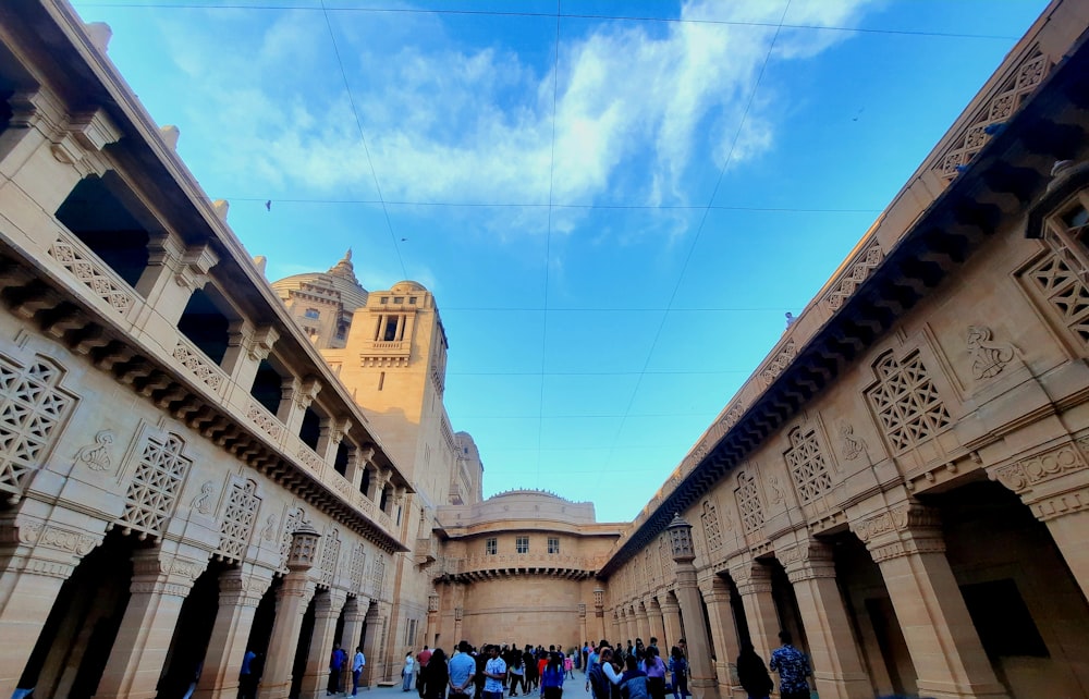 a group of people standing in a courtyard under a blue sky