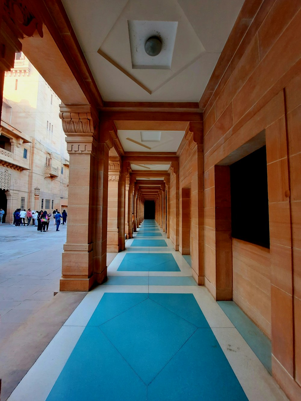a long hallway with blue and white flooring