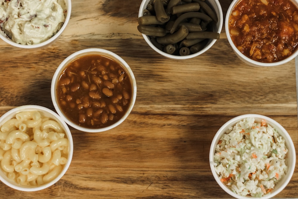 a wooden table topped with bowls of food