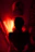 A glowing red-black neon framed portrait of a satisfied customer smiling in a modern luxury bathroom.