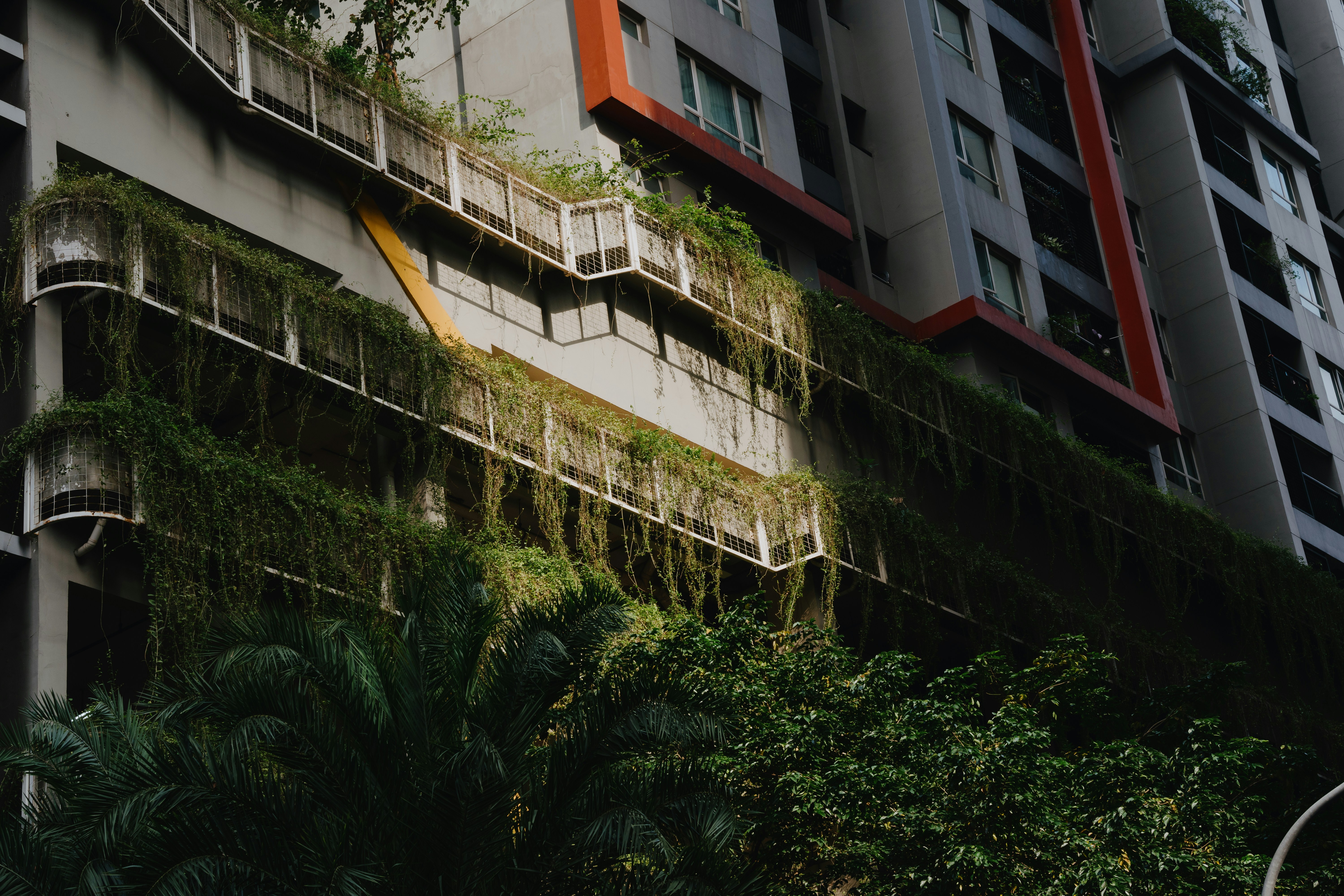 a very tall building with a bunch of plants growing on it