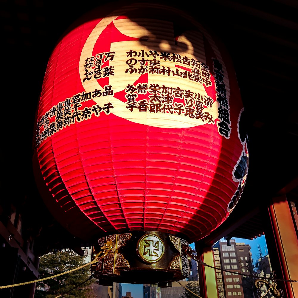 a large red lantern hanging from the side of a building