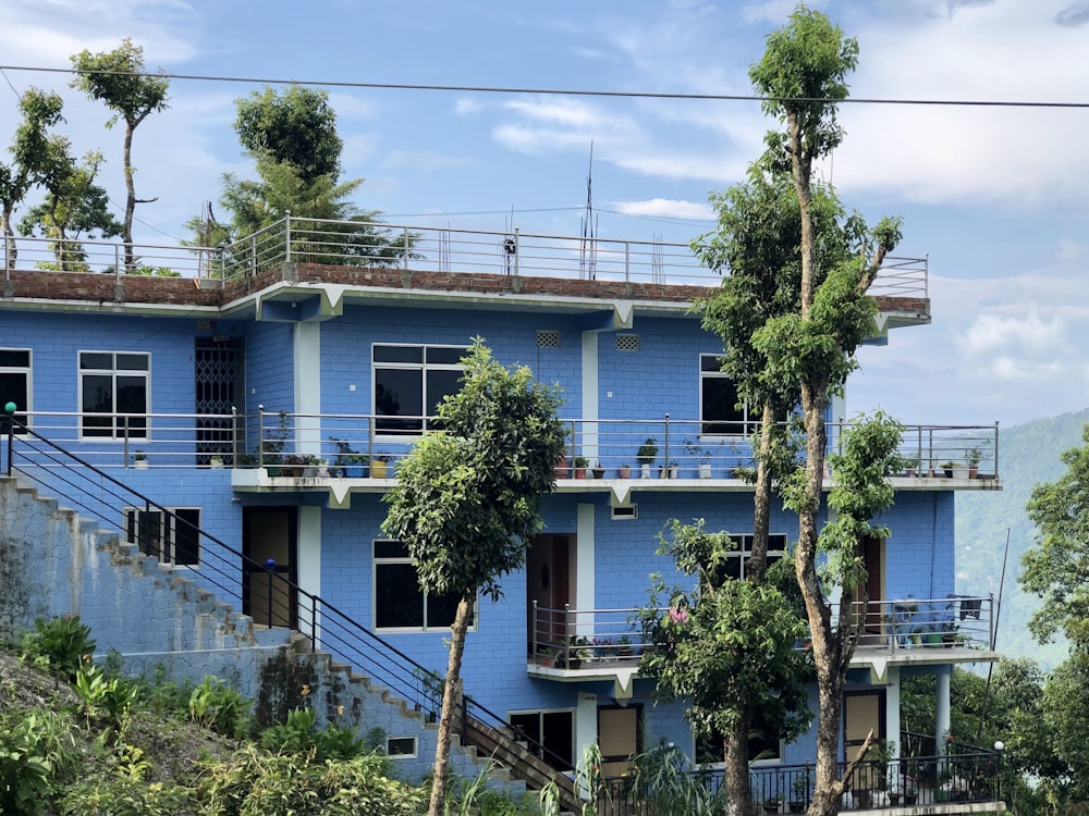a blue building with trees on the side of it