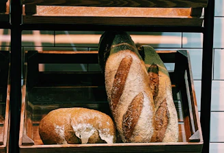 Warm, rustic bakery interior with fresh artisan breads cooling on wooden shelves.