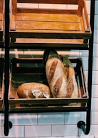 Warm, inviting bakery interior with wooden shelves filled with various breads.