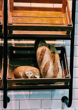 A rustic bakery interior showcasing wooden shelves filled with artisanal breads and pastries.