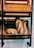 Wooden shelves display freshly baked bread, including two large baguettes and a round loaf positioned neatly. The tiled wall in the background adds a rustic feel.