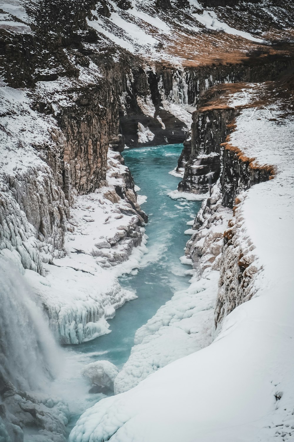 a river running through a snow covered canyon