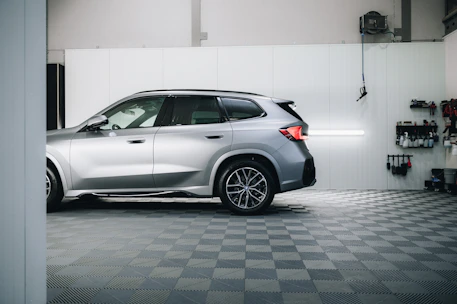a silver bmw suv parked in a garage