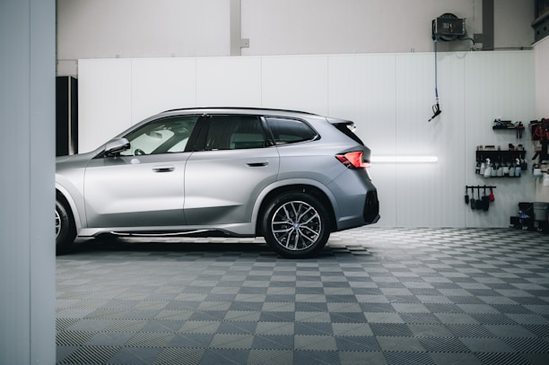 a silver bmw suv parked in a garage