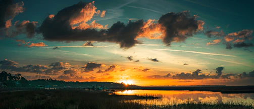 A serene Carolina Low Country marsh at sunset with soft golden light reflecting on the water.