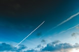 Time-lapse style photo capturing chemtrails slowly expanding and fading.
