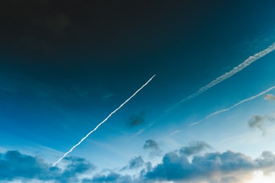 Time-lapse style photo capturing chemtrails slowly expanding and fading.