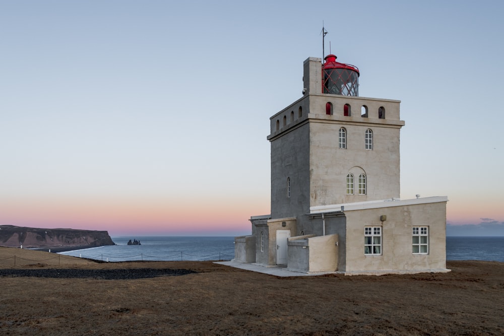 a white lighthouse with a red flag on top of it