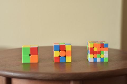 a wooden table topped with three different colored blocks