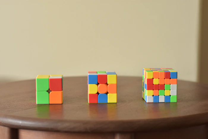 Colorful 2x2, 3x3 and 5x5 cubes on a wooden table