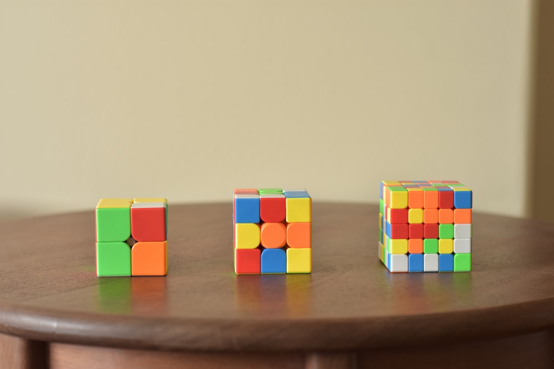 a wooden table topped with three different colored blocks,