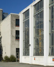 Modern factory building with steel structures and large windows letting in natural light.
