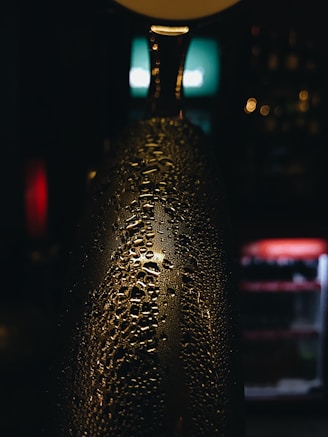 Close-up of chilled craft beer bottles with condensation on a wooden table