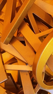 Stack of freshly cut alu letters ready for finishing and installation on a workbench