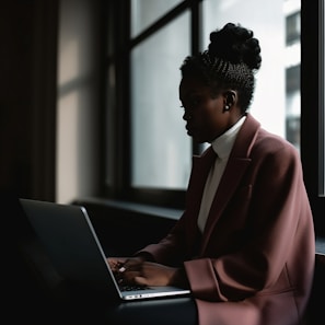 a woman sitting in front of a laptop computer