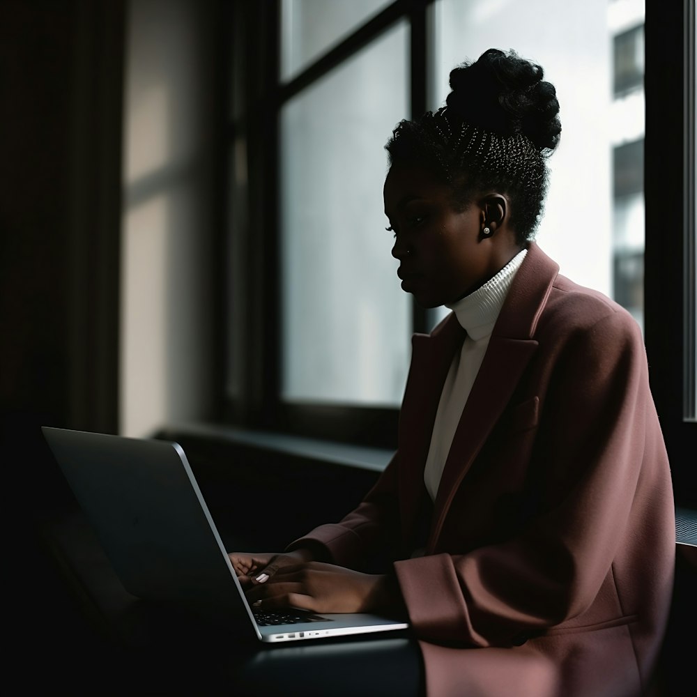 a woman sitting in front of a laptop computer