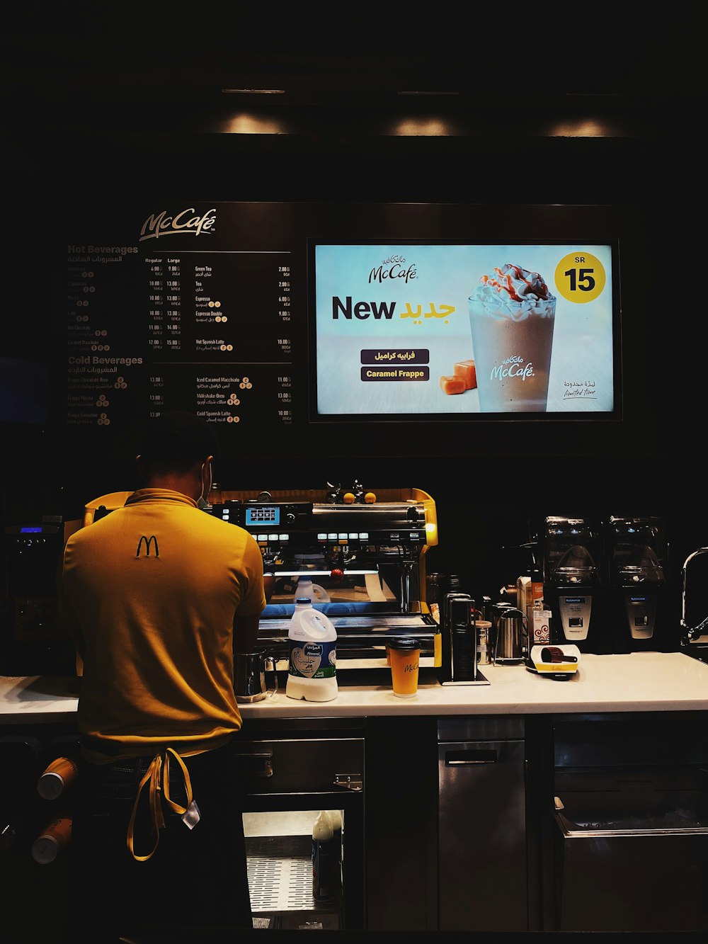 a man standing in front of a menu at a coffee shop