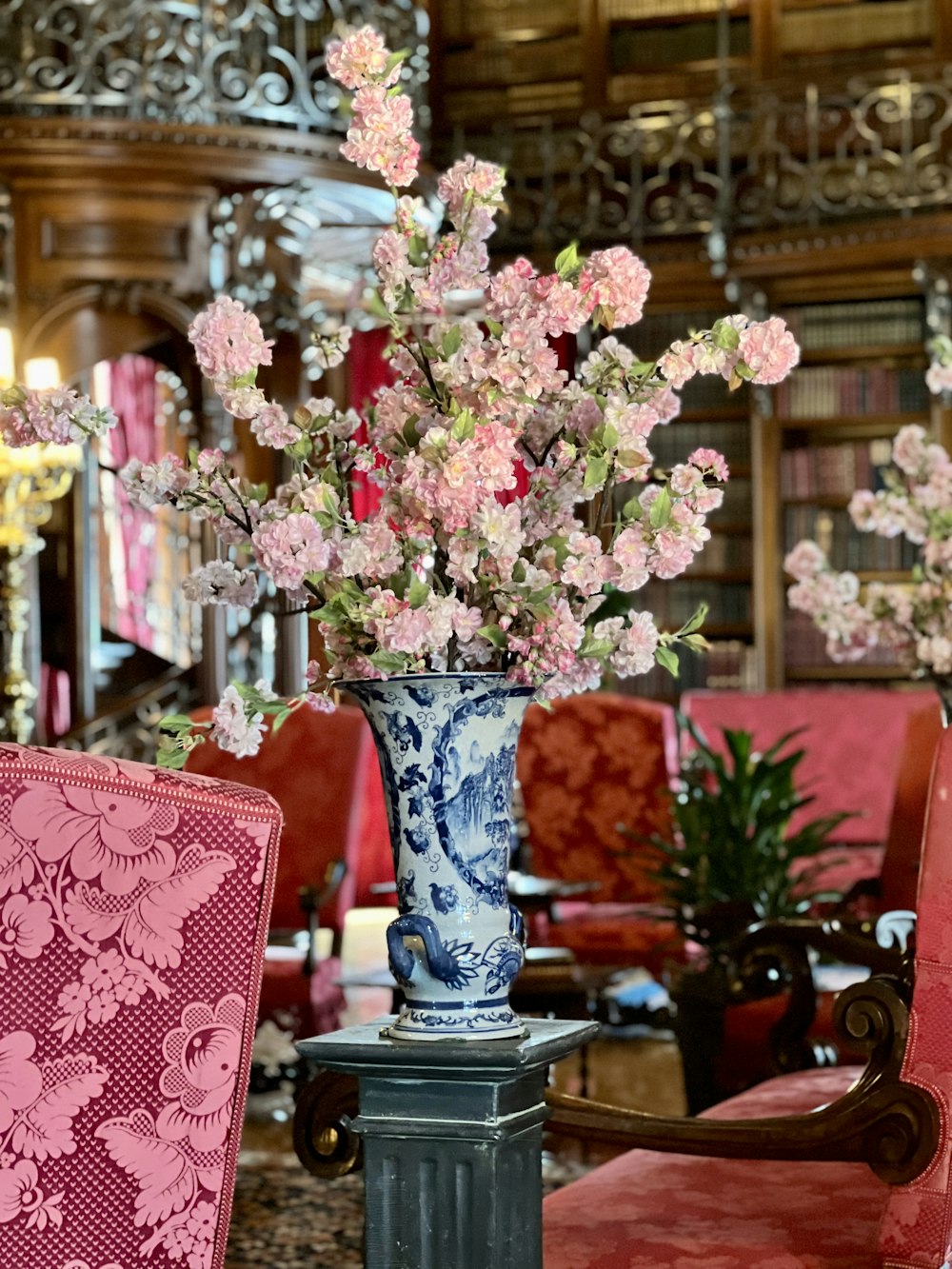 a blue and white vase filled with pink flowers