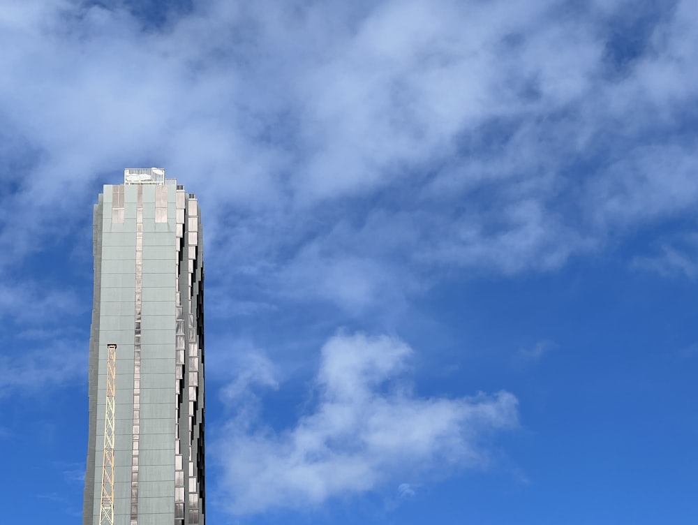 a tall building sitting under a cloudy blue sky