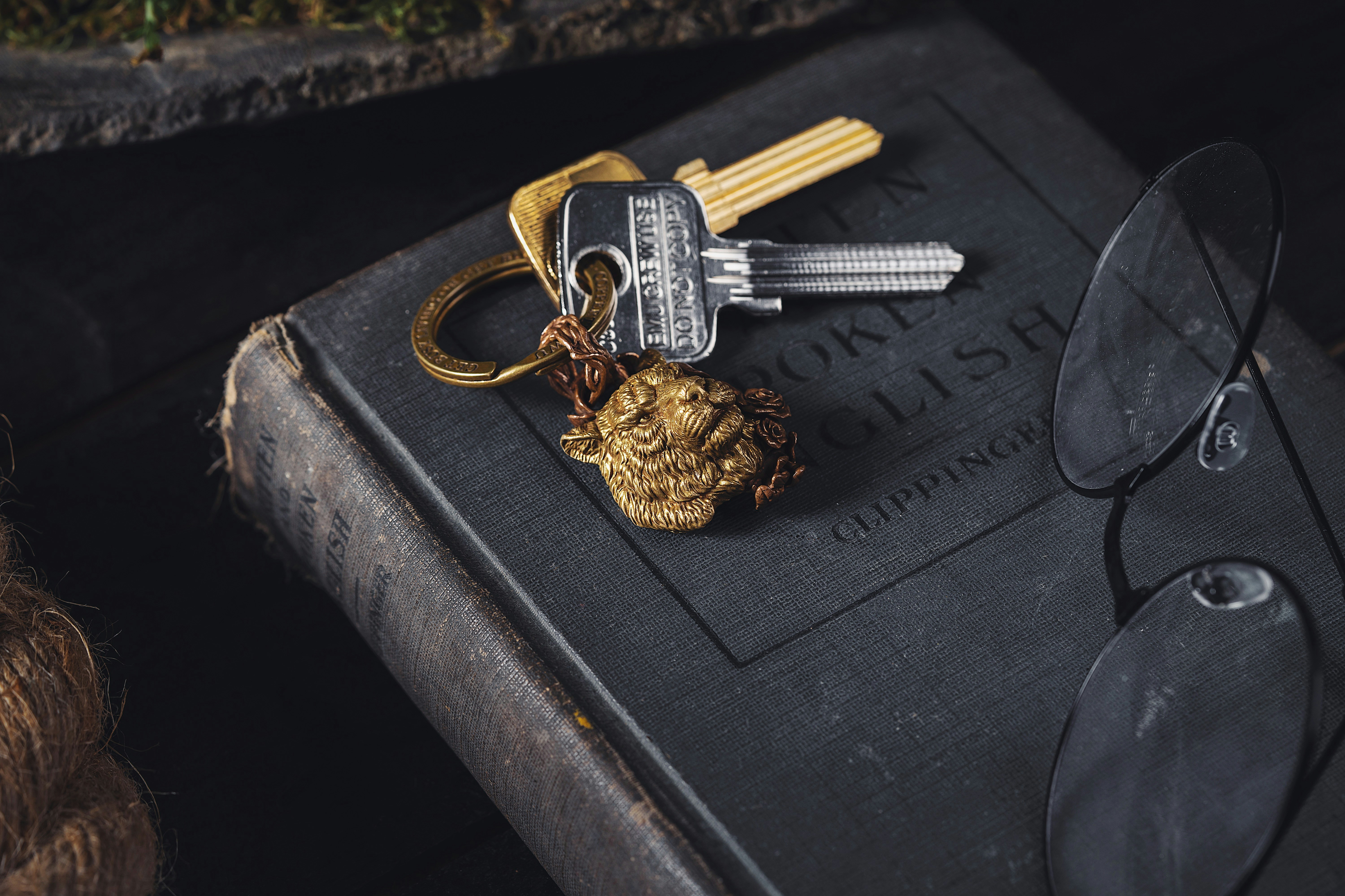 Keys resting on an old book beside reading glasses