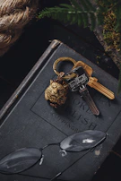 A vintage brass key resting on an aged wooden table beside a leather-bound book.