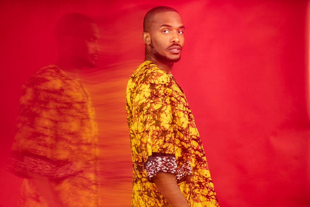 a man standing in front of a red background