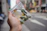 A happy customer receiving a discreet package from a Reno Budz delivery driver on a sunny Brooklyn street.