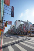 A bustling street scene with various local businesses and advertisement boards.