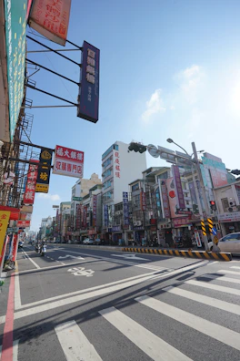 A bustling street scene with various local businesses and advertisement boards.