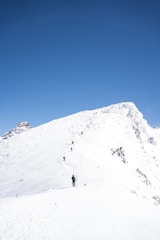 A mountain guide leading a small group along a rocky ridge