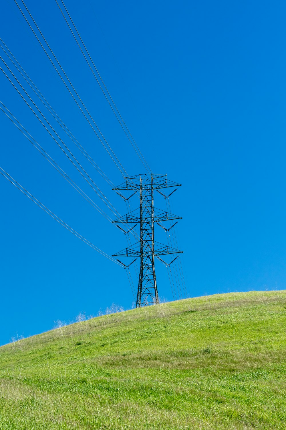a power line on a hill with a blue sky in the background