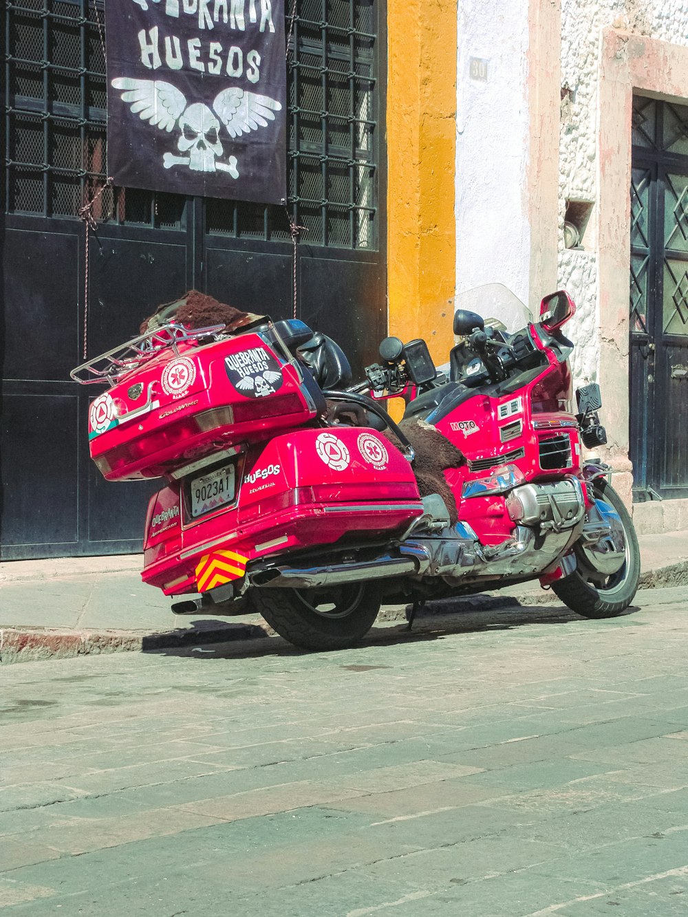 a red motorcycle parked in front of a building