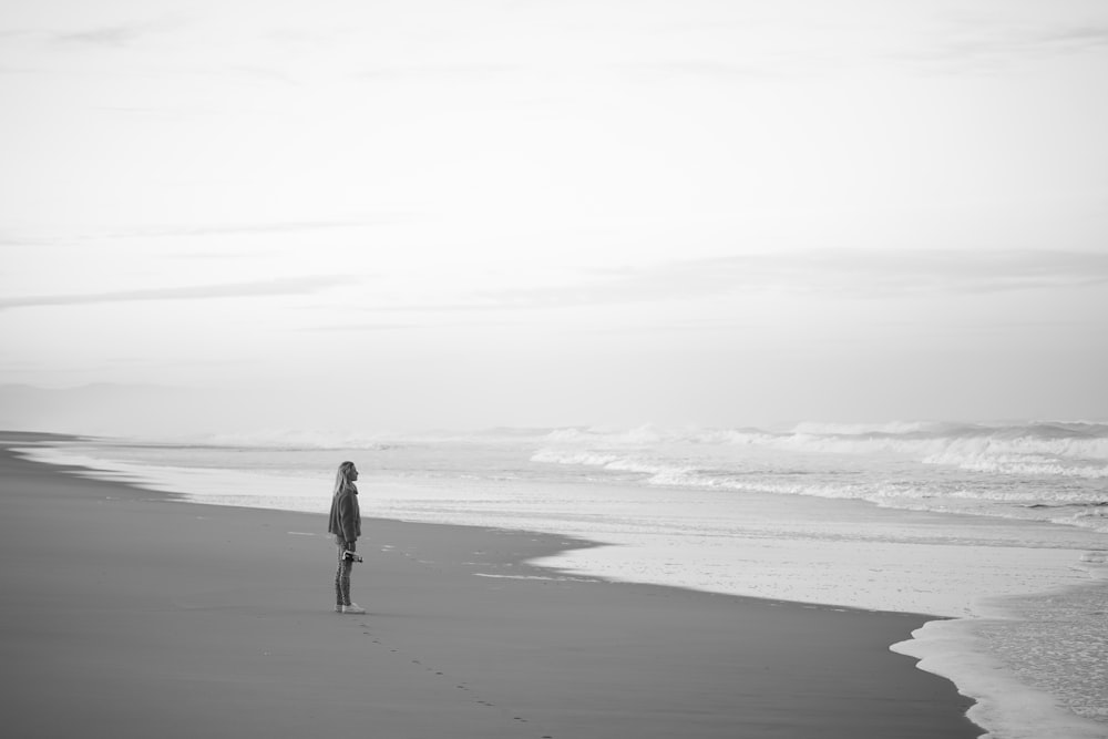 a person standing on a beach next to the ocean